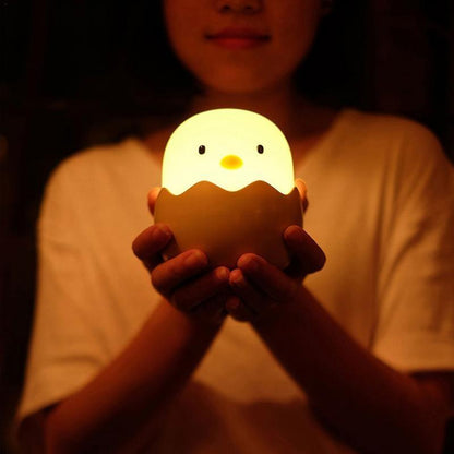 a girl holding the night light in her hands 