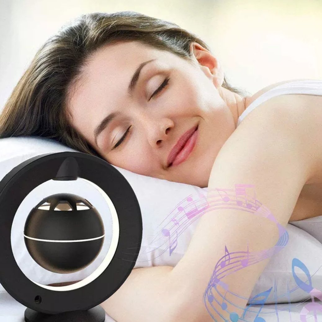 a girl sleeping beside the levitating bluetooth speaker 