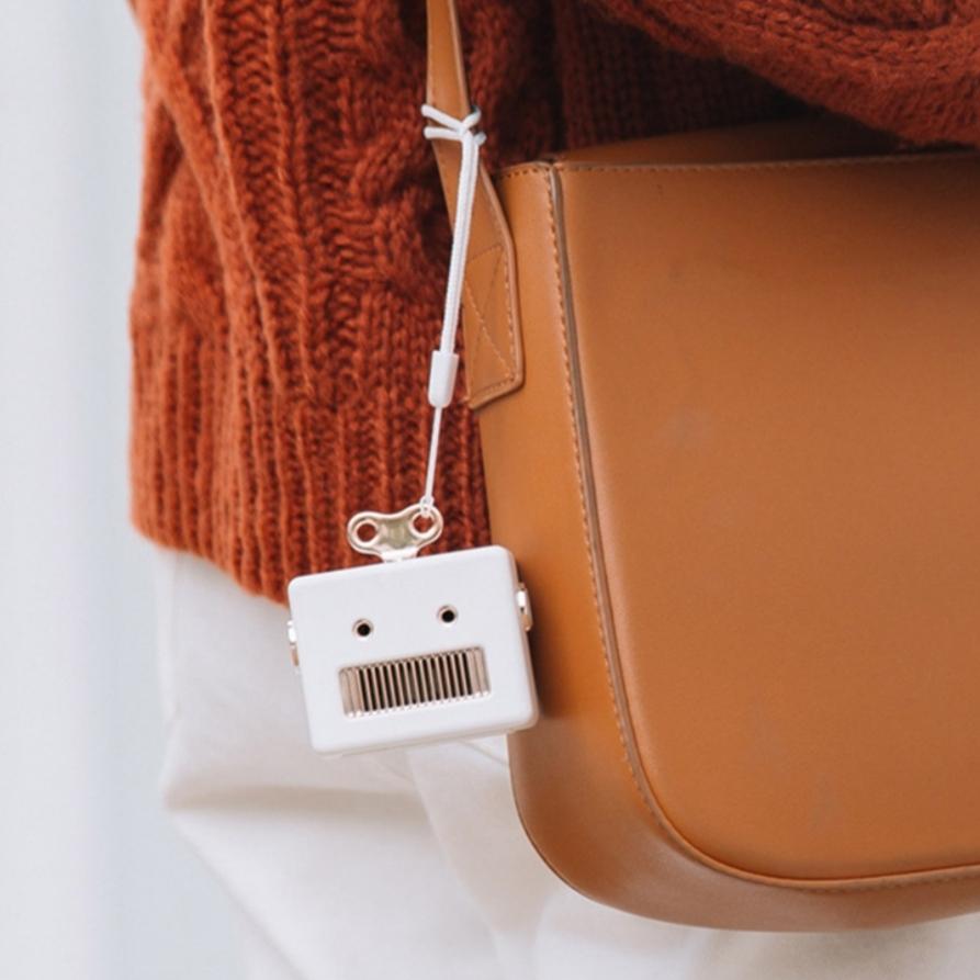 mini bluetooth speaker tied on a handbag 